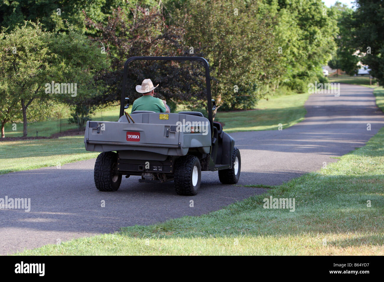 A gardener driving a utility vehicle cart Stock Photo Alamy