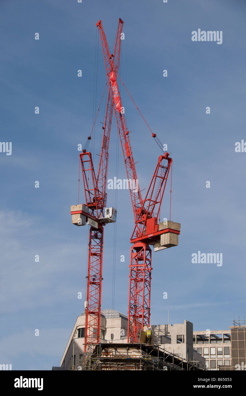 Two red cranes against blue sky with white clouds Stock Photo - Alamy