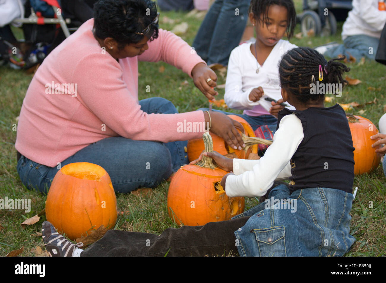 Mother and children carve pumpkins donated by Nalls Farm Market at the 2008 Shenandoah Valley Hot Air Balloon Festival in VA. Stock Photo