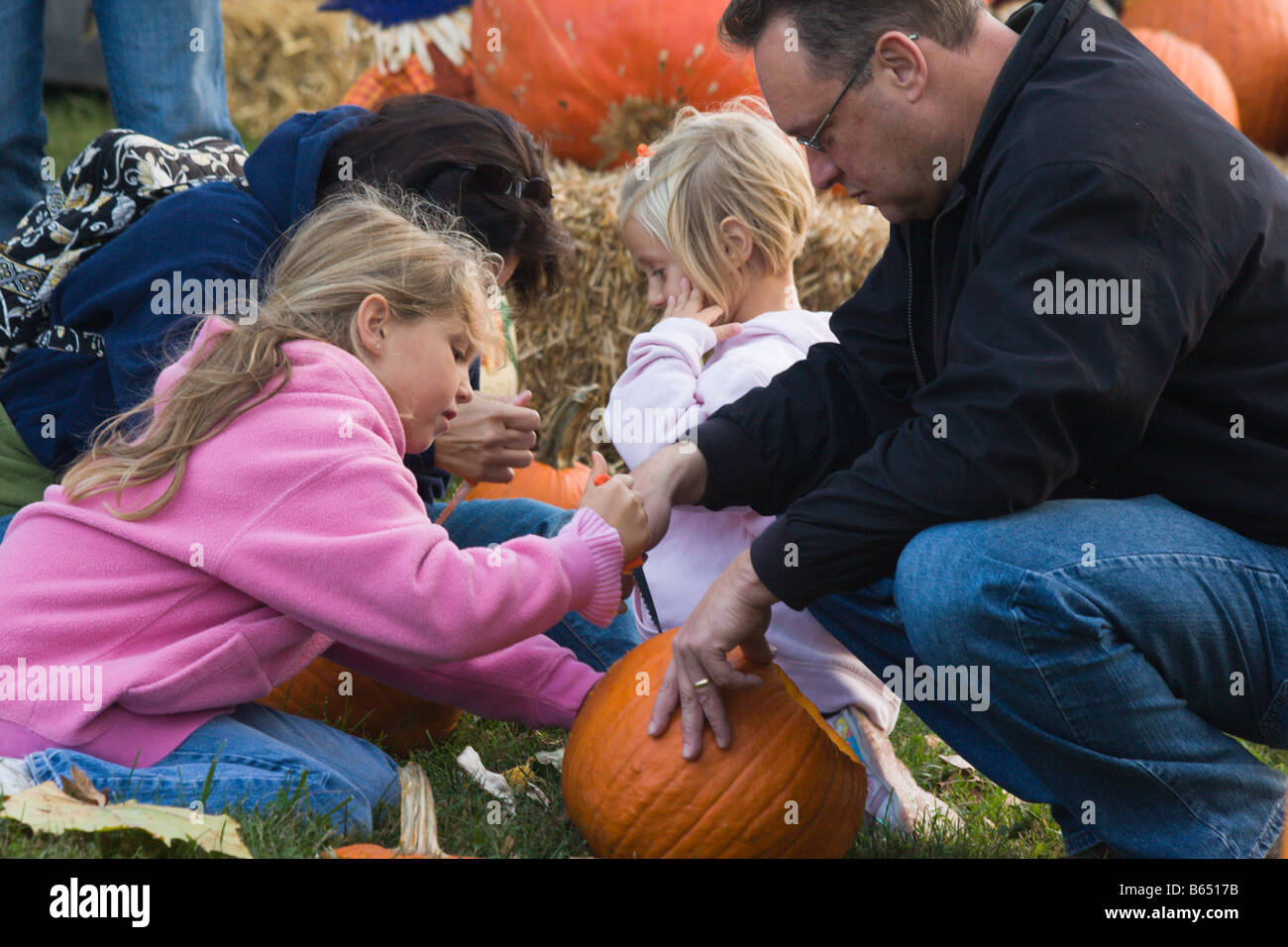 Father and children carve pumpkins at the 2008 Shenandoah Valley Hot Air Balloon and Wine Festival at Historic Long Branch in VA Stock Photo