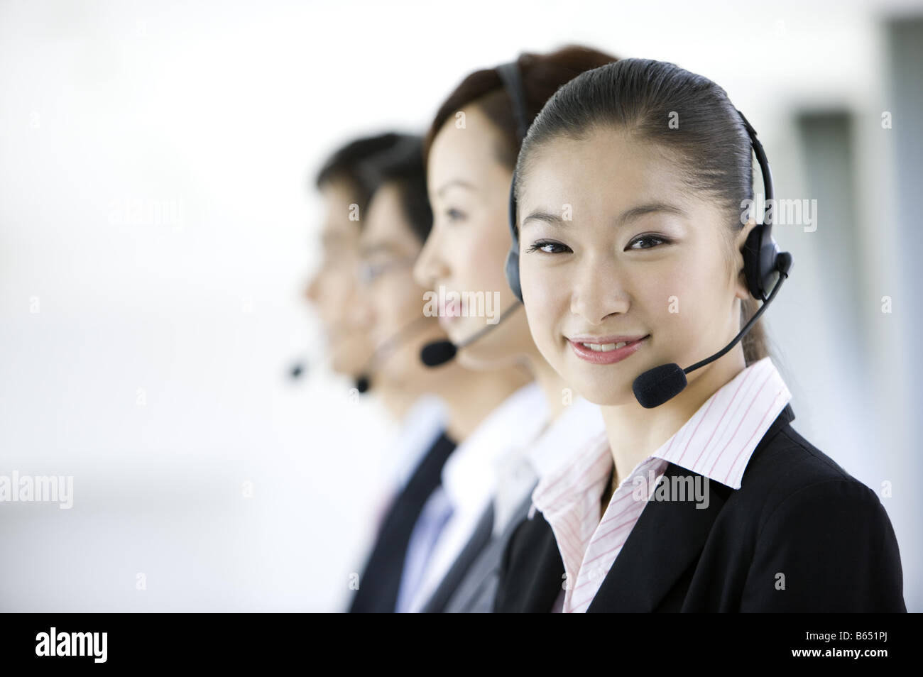 Business people wearing head phone in a row Stock Photo