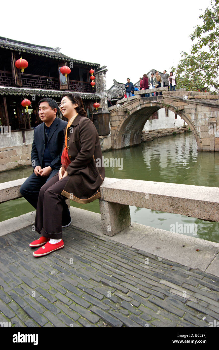 Chinese tourist couple posing by canal in front of twin stone bridges Water Town Venice of the east Stock Photo