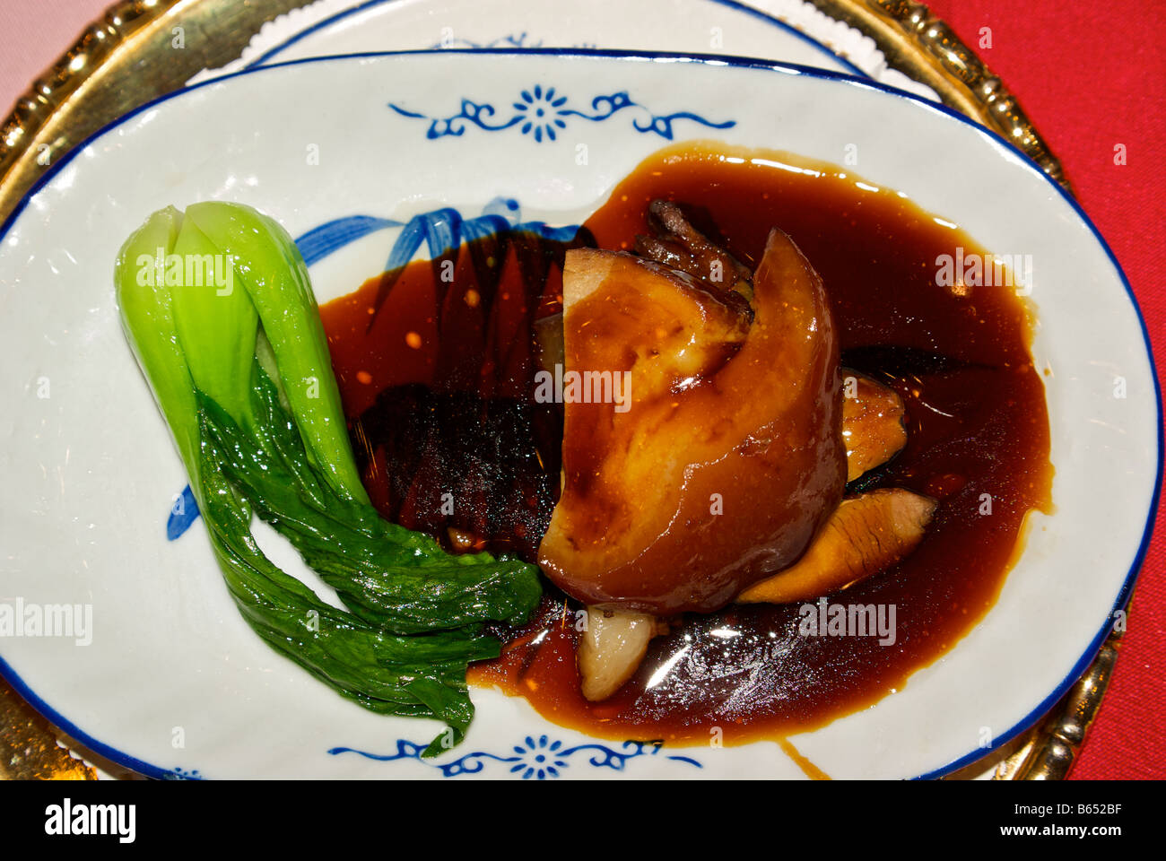 Renowned brown sugar soy sauce glazed braised Wansan upper pork leg from Zhouzhuang Water Town with bok choy Chinese cabbage Stock Photo