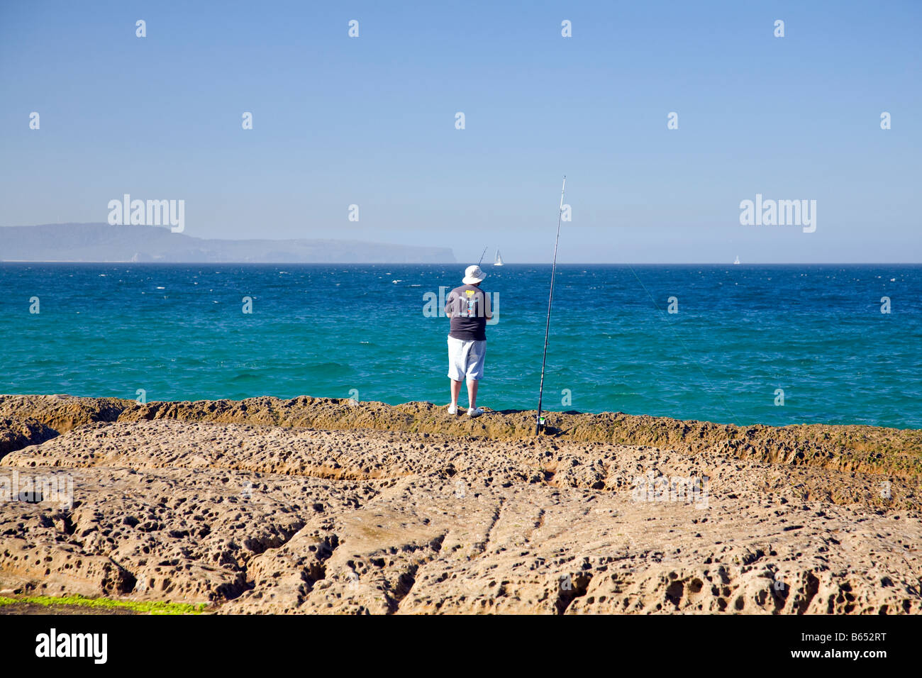 Man sea fishing off the rocks near Whale beach in Sydney, New South ...