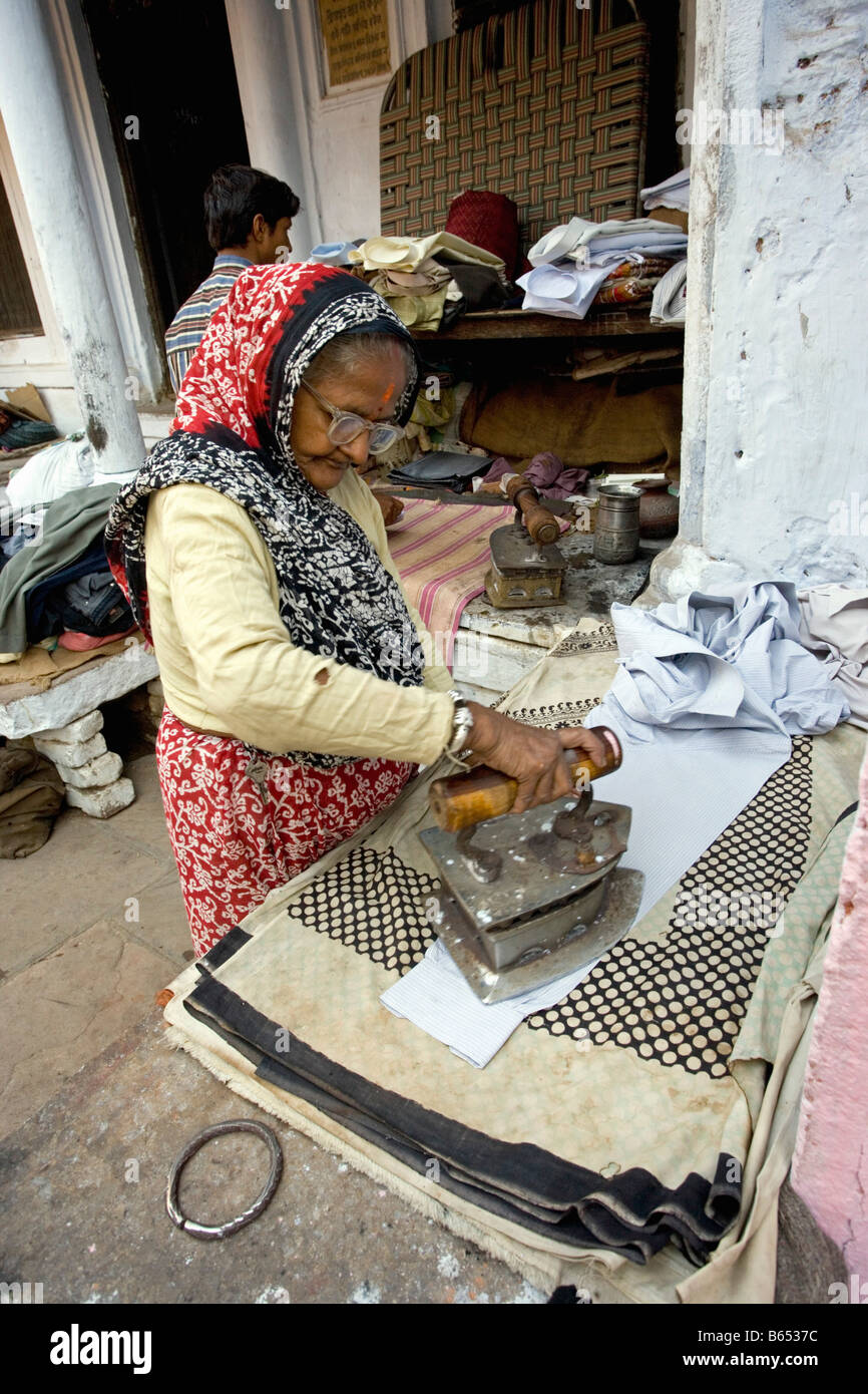 asia, asian, india, woman ironing cloth with an old fashioned