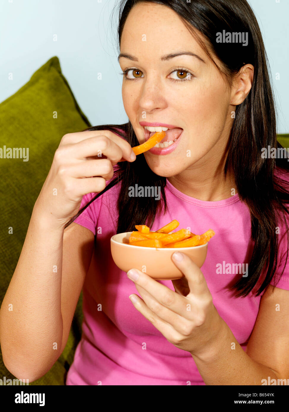 Young Woman Eating Carrot Sticks Model Released Stock Photo