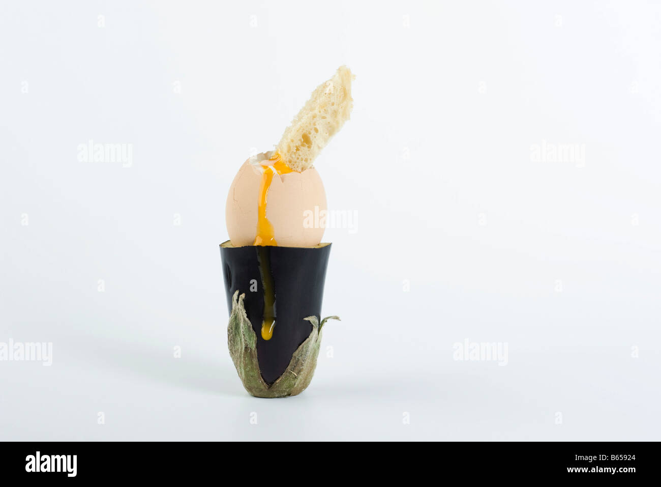Soft-boiled egg with piece of toast in eggplant holder Stock Photo
