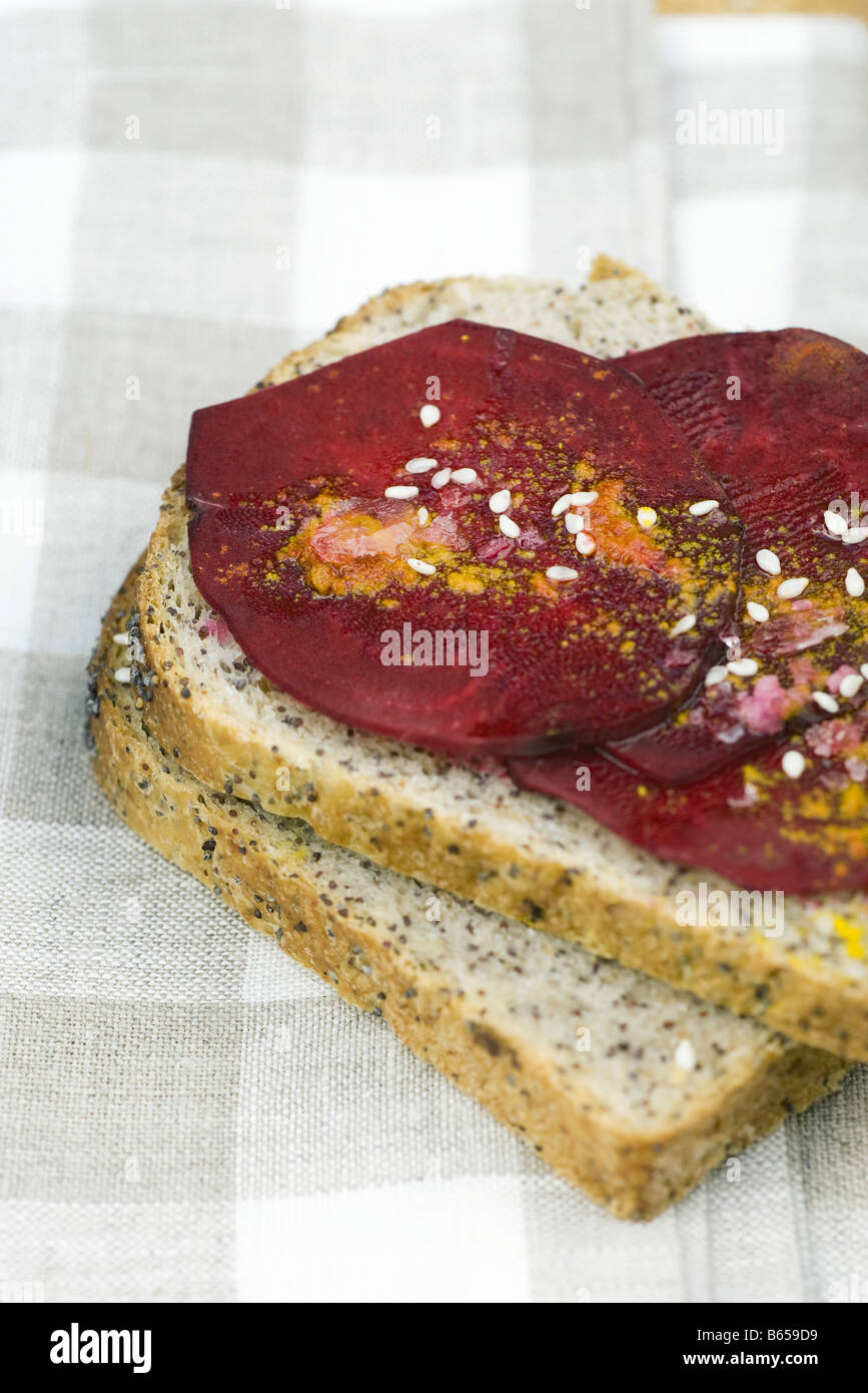 Slices of beet on bread, topped with sesame seeds and spices Stock Photo