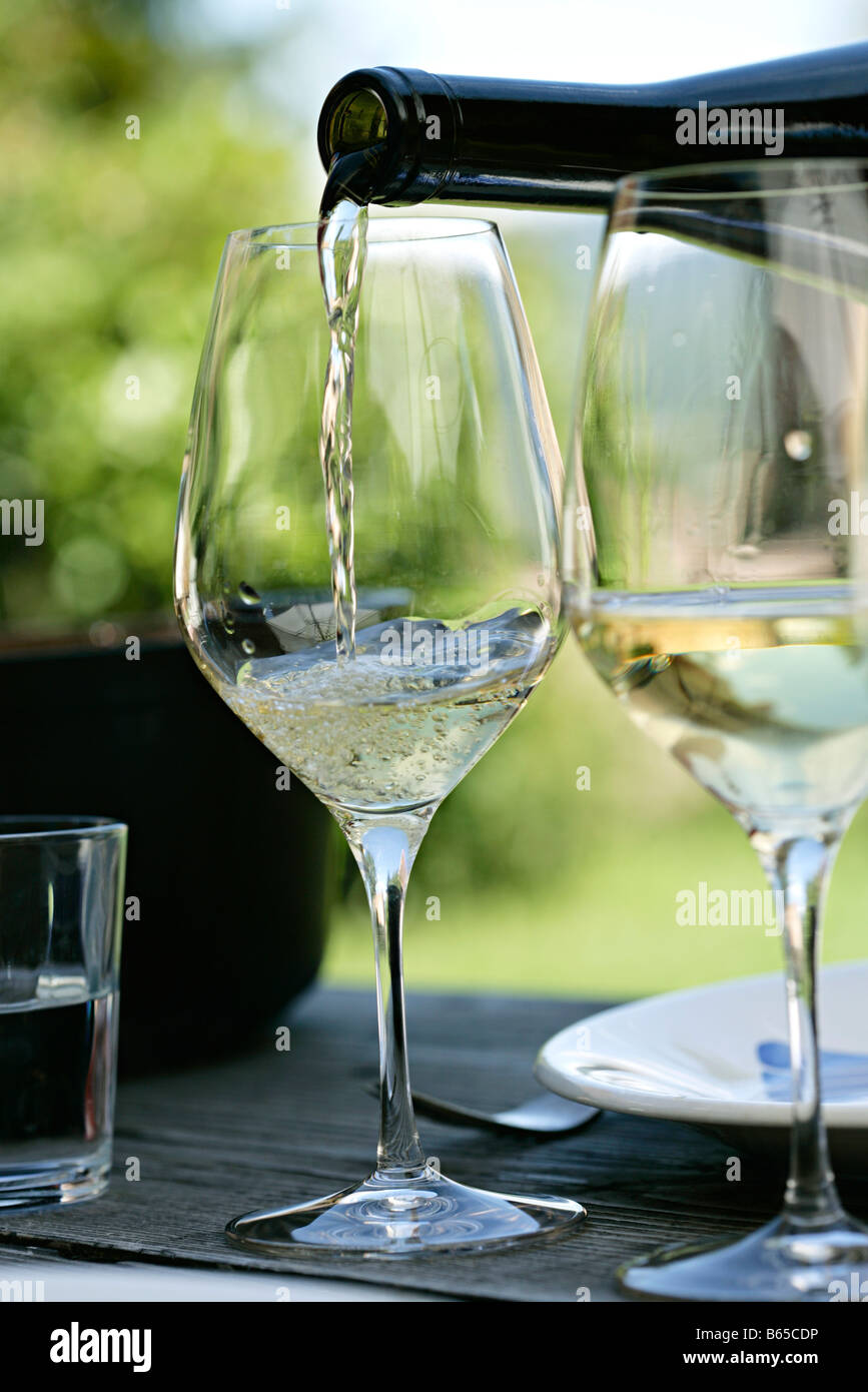 White wine being poured into wine glasses Stock Photo