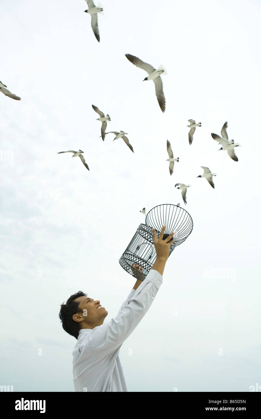 Man releasing bird outdoors, open cage in hand Stock Photo Alamy