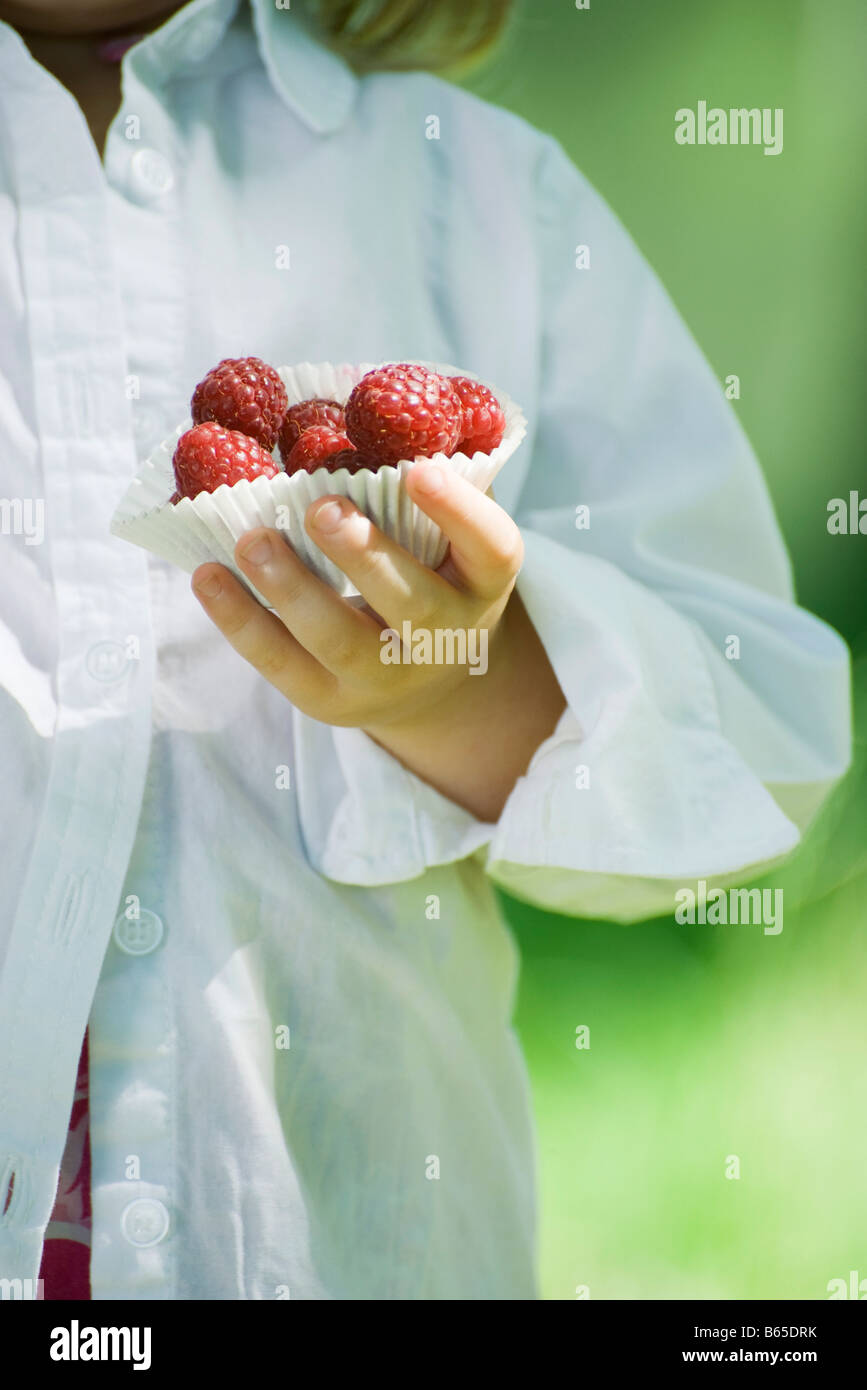 Wrapper Girl Little girl holding cupcake wrapper full of raspberries, cropped Stock ...