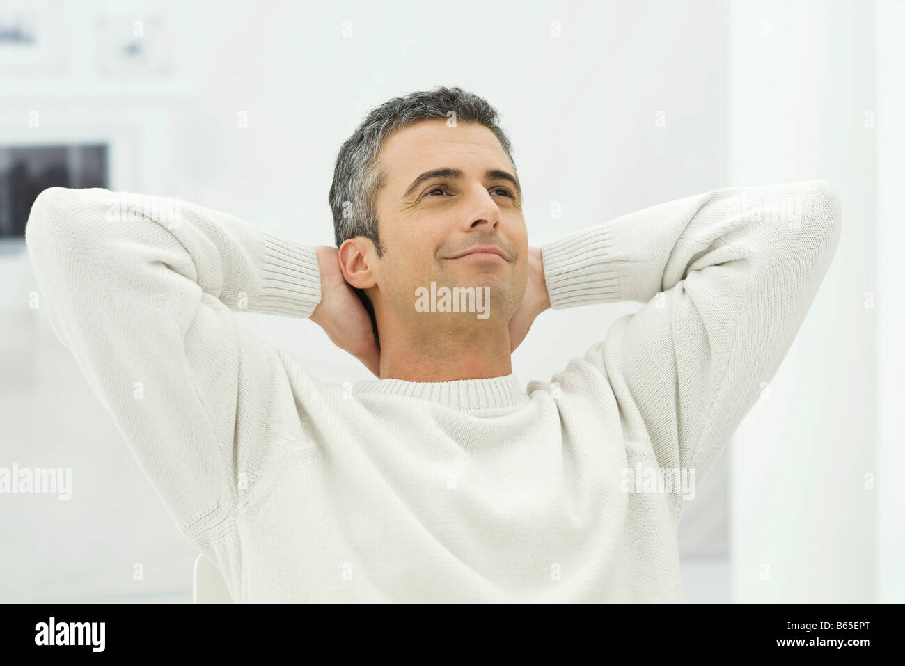 Man leaning back with hands behind head, smiling Stock Photo Alamy