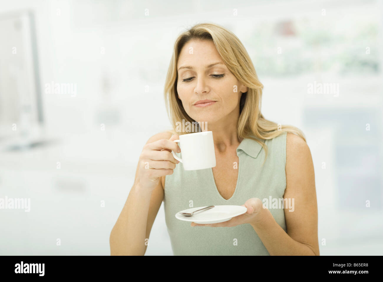 Woman holding coffee cup, smiling Stock Photo