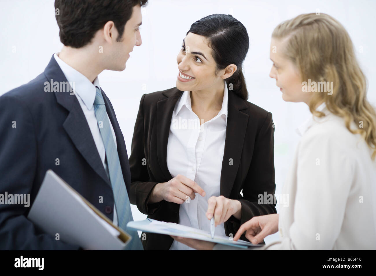 Business associates looking at document together Stock Photo