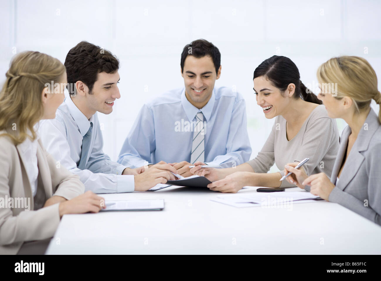 Group of professionals sitting at table, discussing document Stock Photo