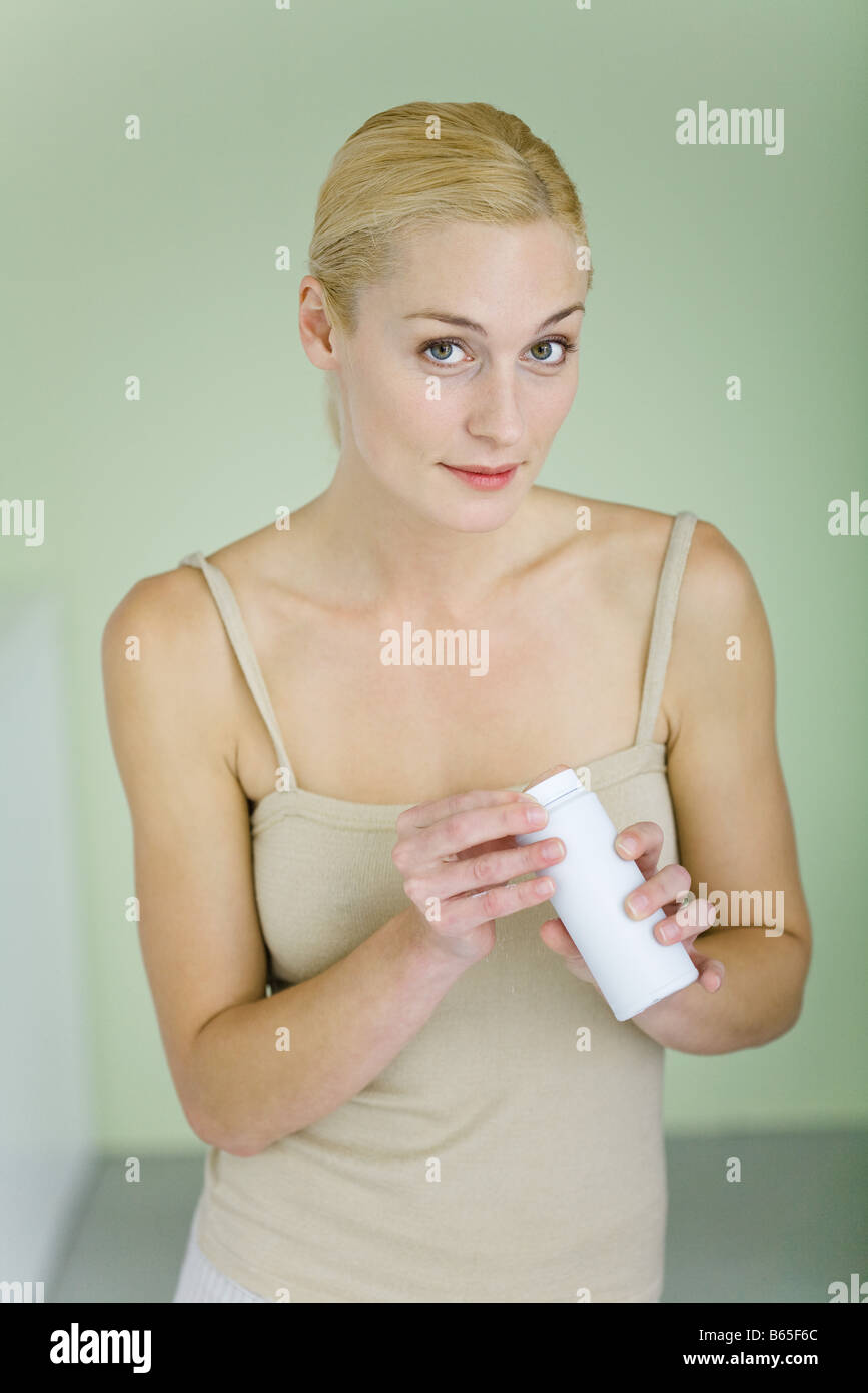 Mother holding bottle of baby powder, smiling at camera Stock Photo Alamy