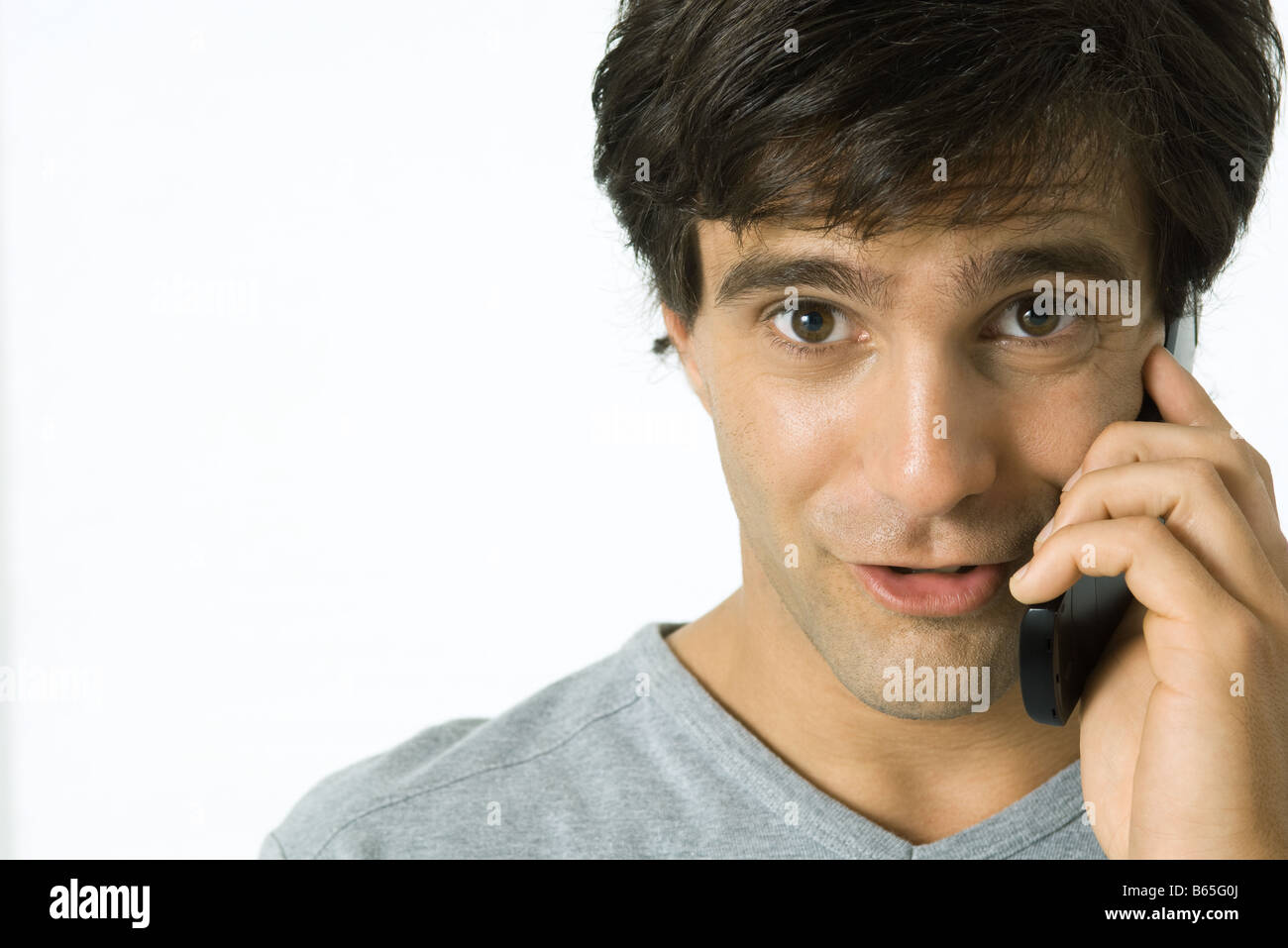 Man using cell phone, making faces at camera, portrait Stock Photo