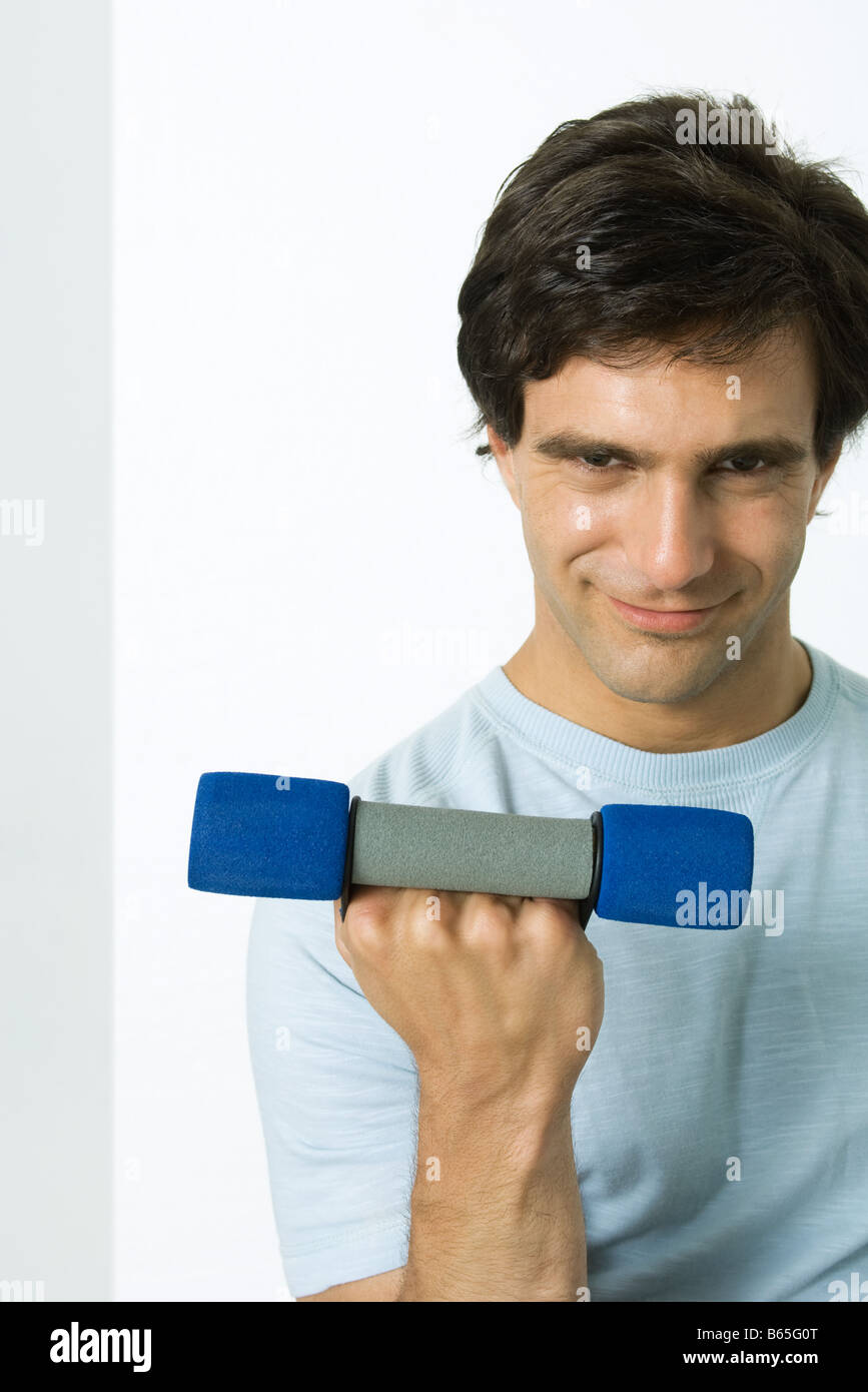 Man lifting dumbbell, smirking at camera Stock Photo