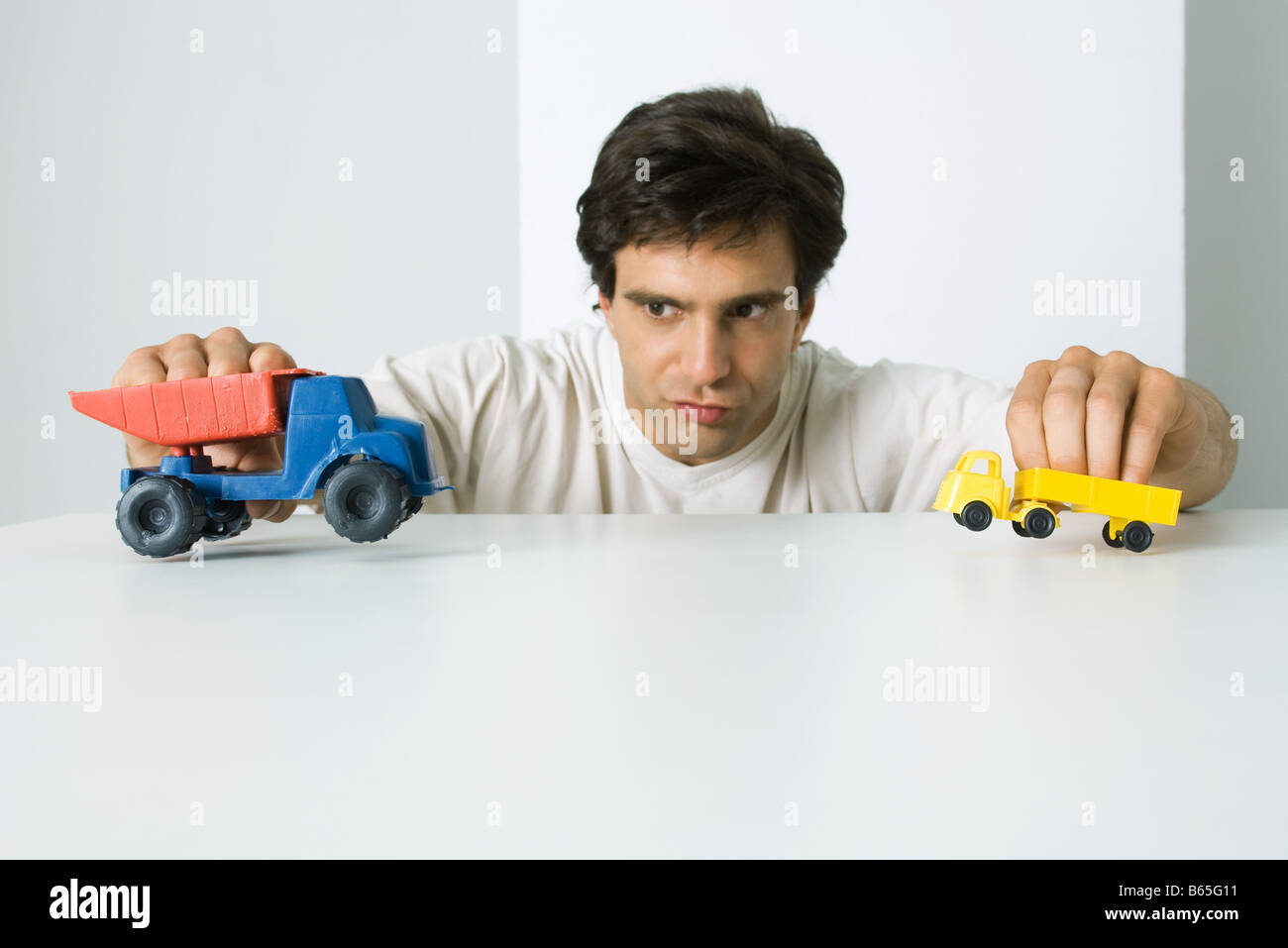 Man playing with toy trucks Stock Photo