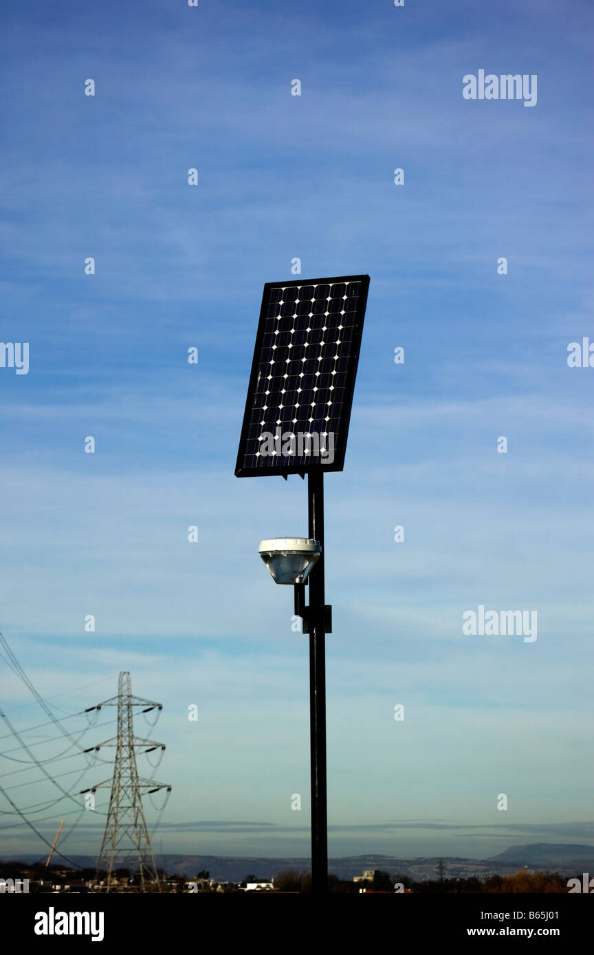 Solar panel for street lighting with electricity power pylons in background Scotland UK Europe Stock Photo