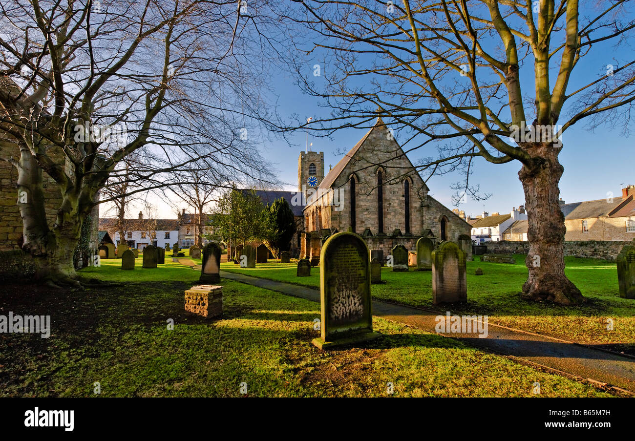 Country churchyard on sunny day blue sky and trees without leaves Stock Photo