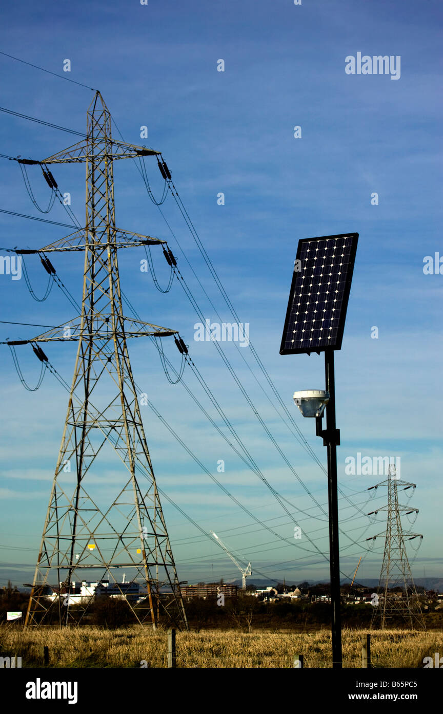 Solar panel for street lighting with electricity power pylons in background Scotland UK Europe Stock Photo