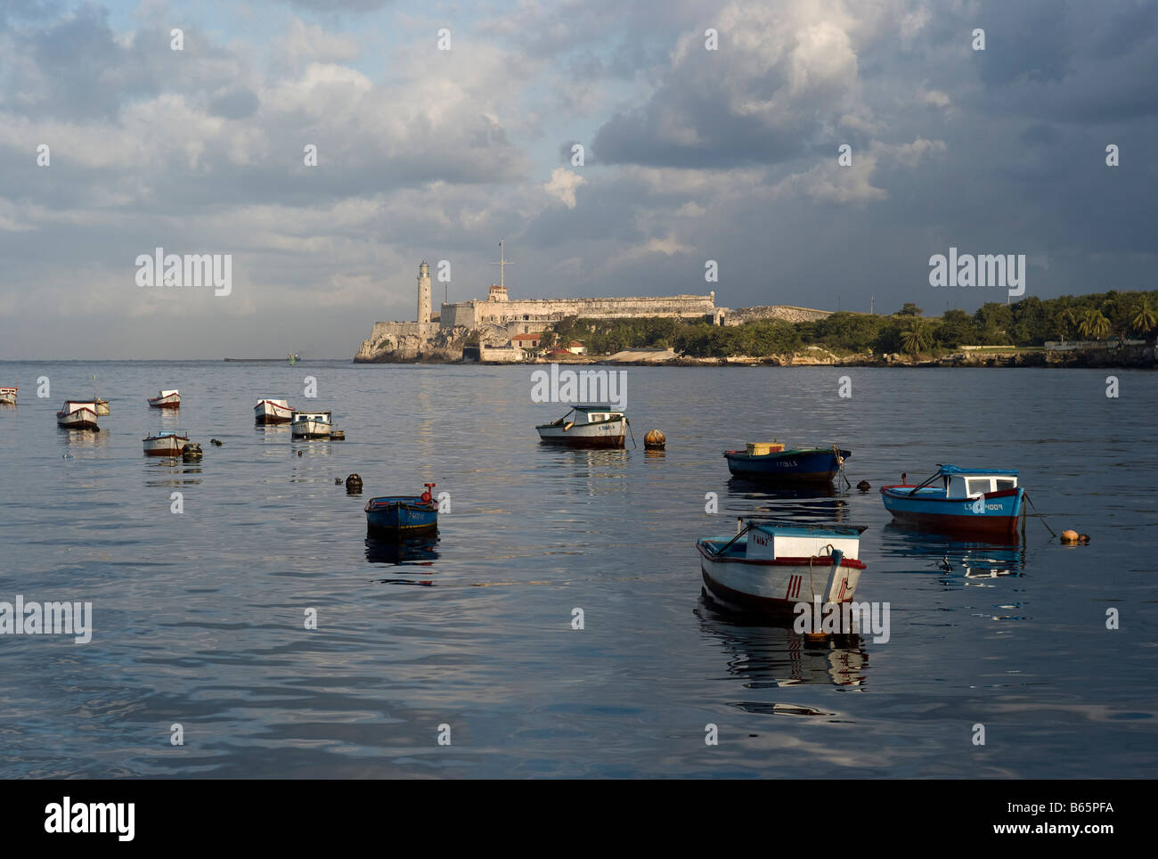 Lighthouse at the entrance to the port of Havana with small fishing boats in foreground. Taken early morning in November. Stock Photo