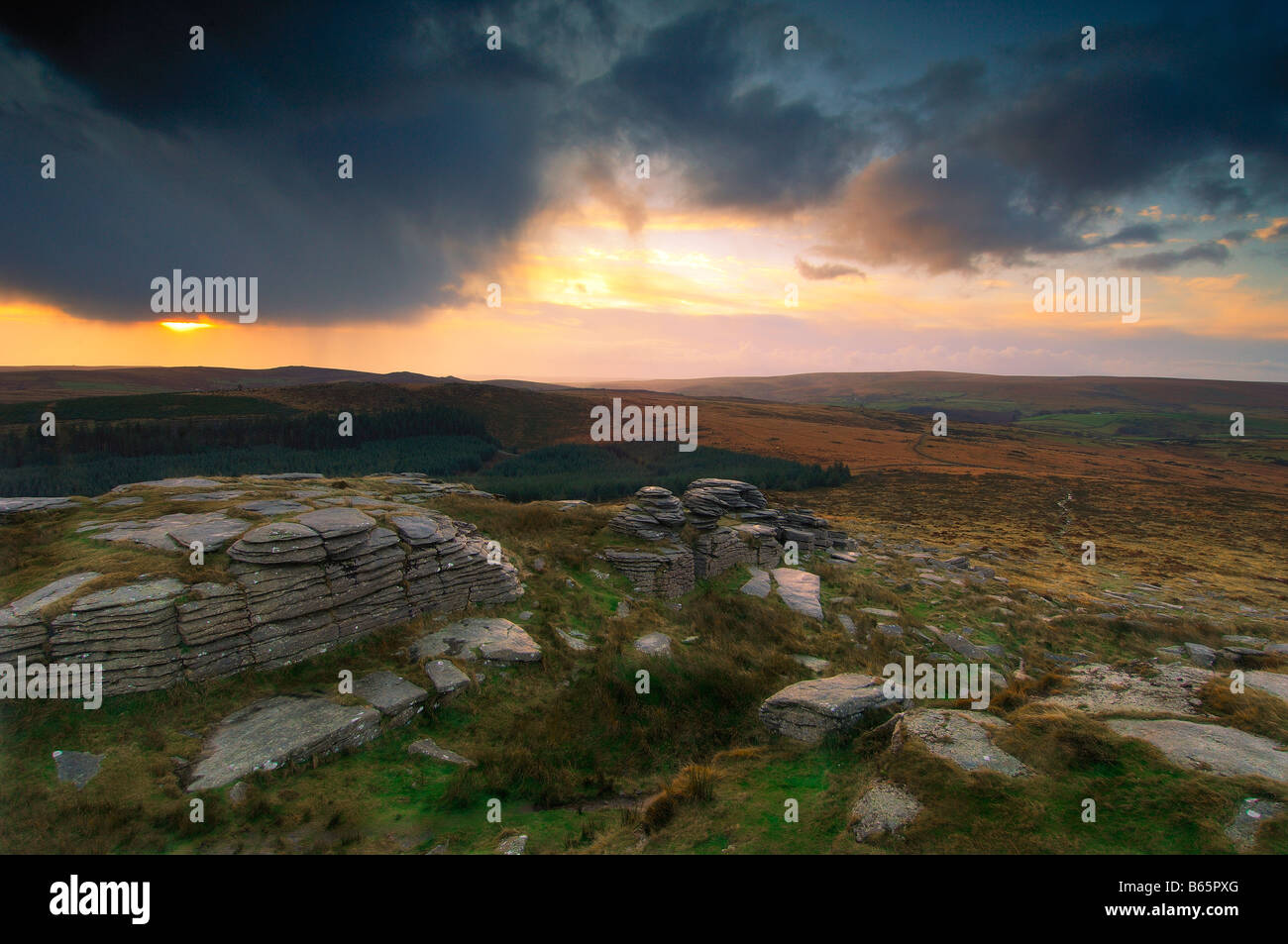 Beautiful and dramatic sunrise at Bellever Tor Dartmoor South Devon England with breaking cloud and the first light of dawn Stock Photo