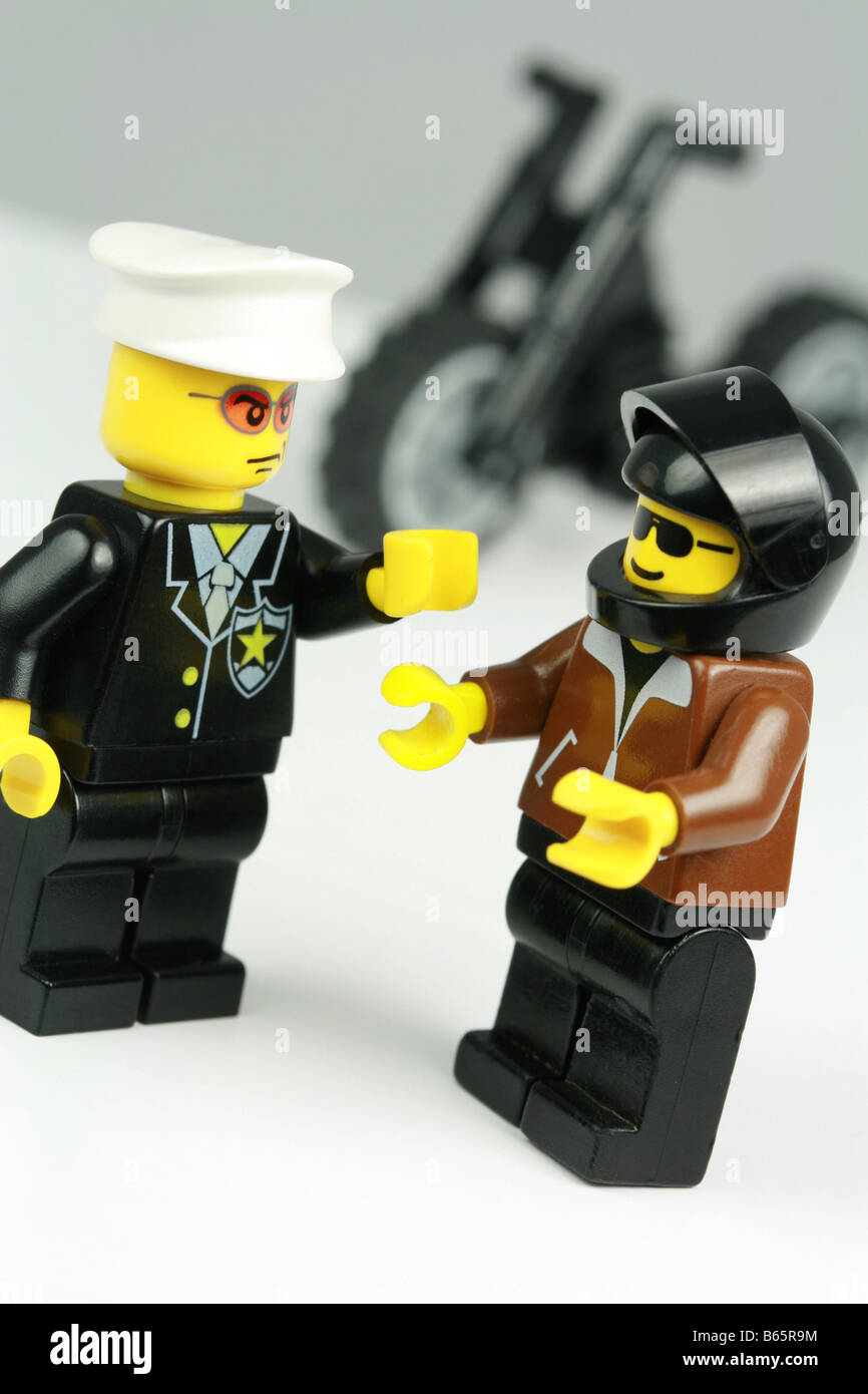 irresponsible lego motorcyclist being reprimanded by a lego policeman Stock Photo