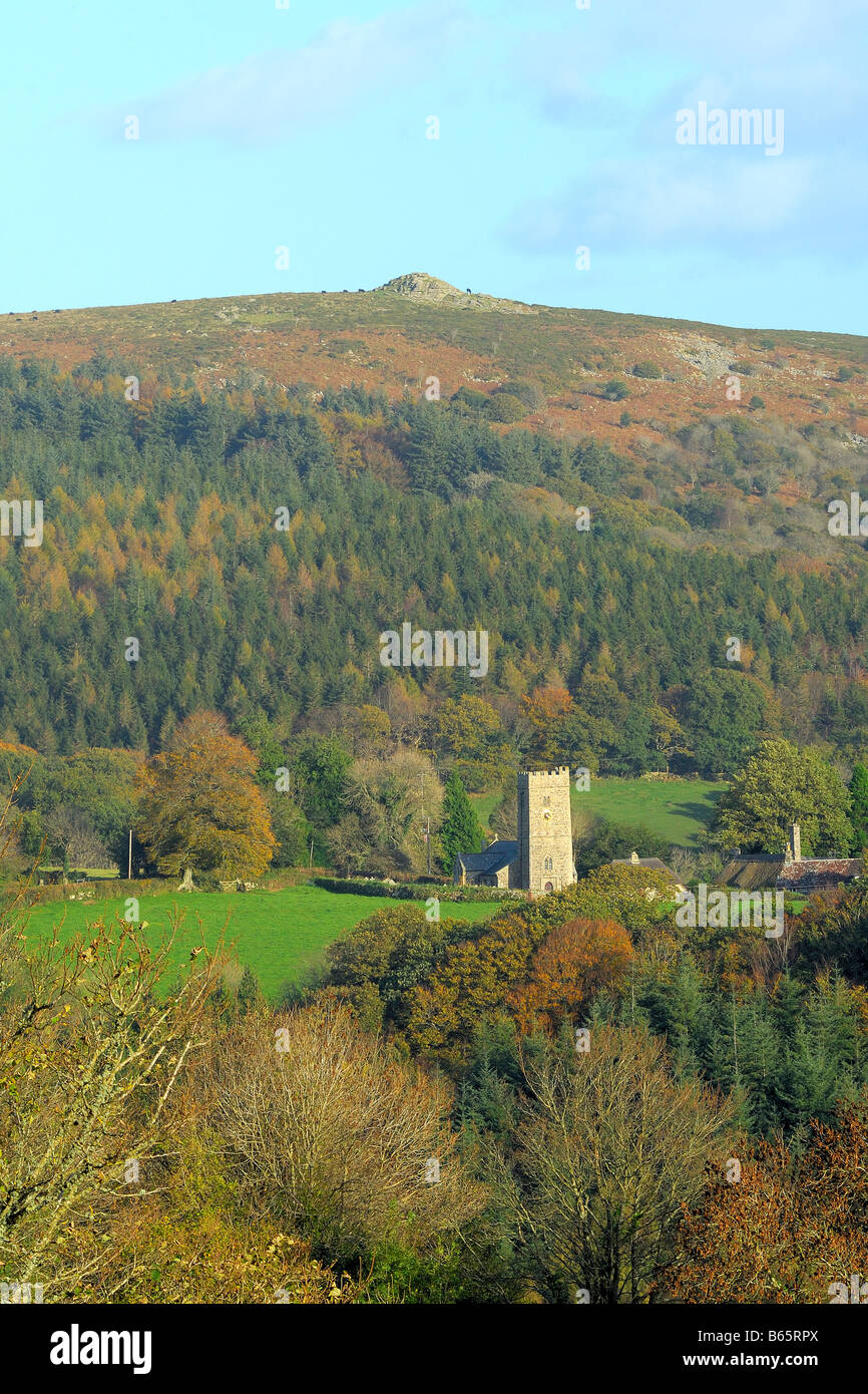 St Peters church at Buckland in the Moor below Buckland Beacon on Dartmoor National Park and surrounded by autumnal woodland Stock Photo