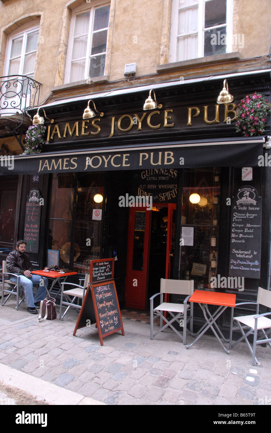 A young visitor relaxing with a drink outside an Irish pub called the James  Joyce pub in Rue St Jean in the district of (old ) V Stock Photo - Alamy