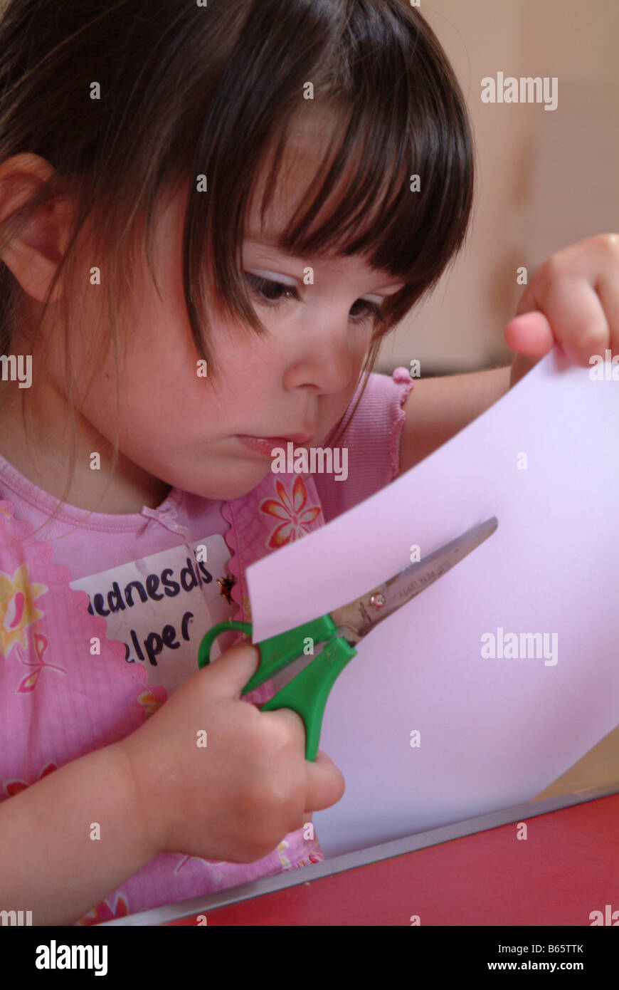 Little girl using scissors to cut out a circle Stock Photo Alamy