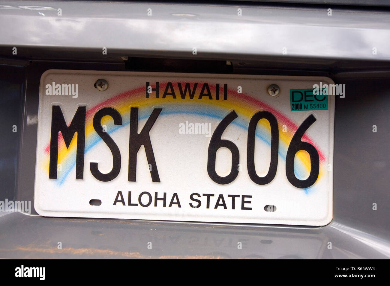 Hawaiian license plate on back of car with rainbow and text "Aloha