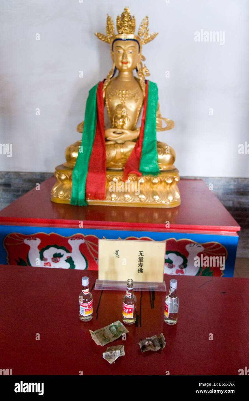 Statue with prayer shawls and offerings at Buddhist temple Xilinhot