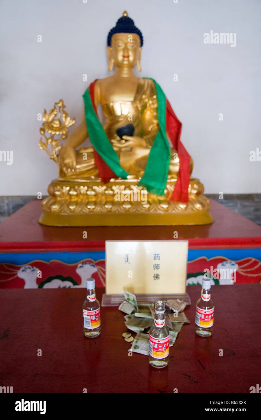 Statue with prayer shawls and offerings at Buddhist temple Xilinhot