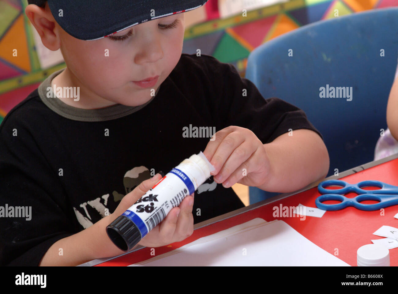 Little boy using a gluestick for sticking paper Stock Photo Alamy