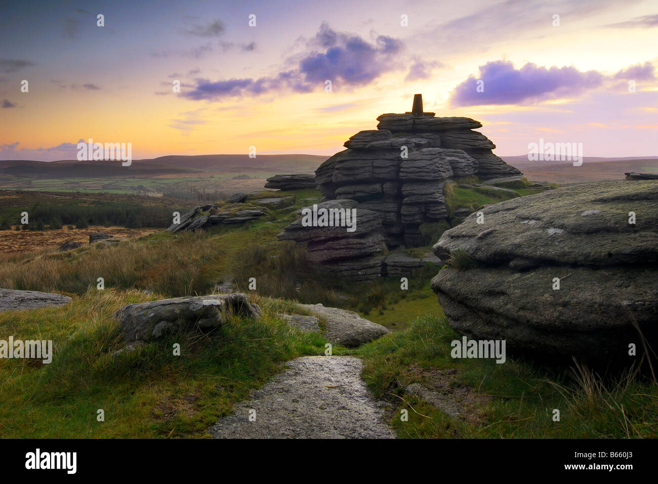 Beautiful and dramatic sunrise at Bellever Tor Dartmoor South Devon England with breaking cloud and the first light of dawn Stock Photo
