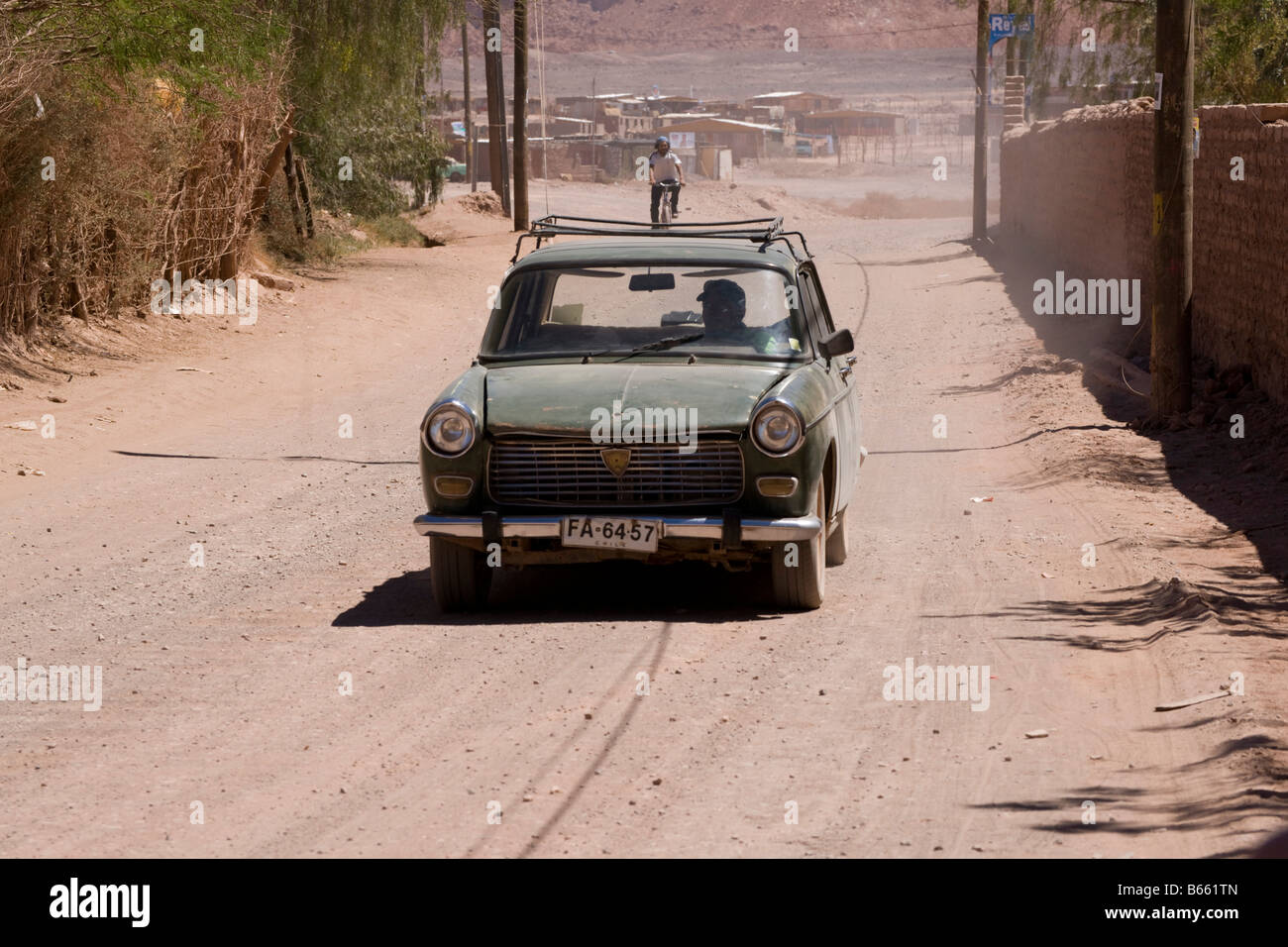 Typical dusty road and old car in San Pedro de Atacama, Chile Stock Photo