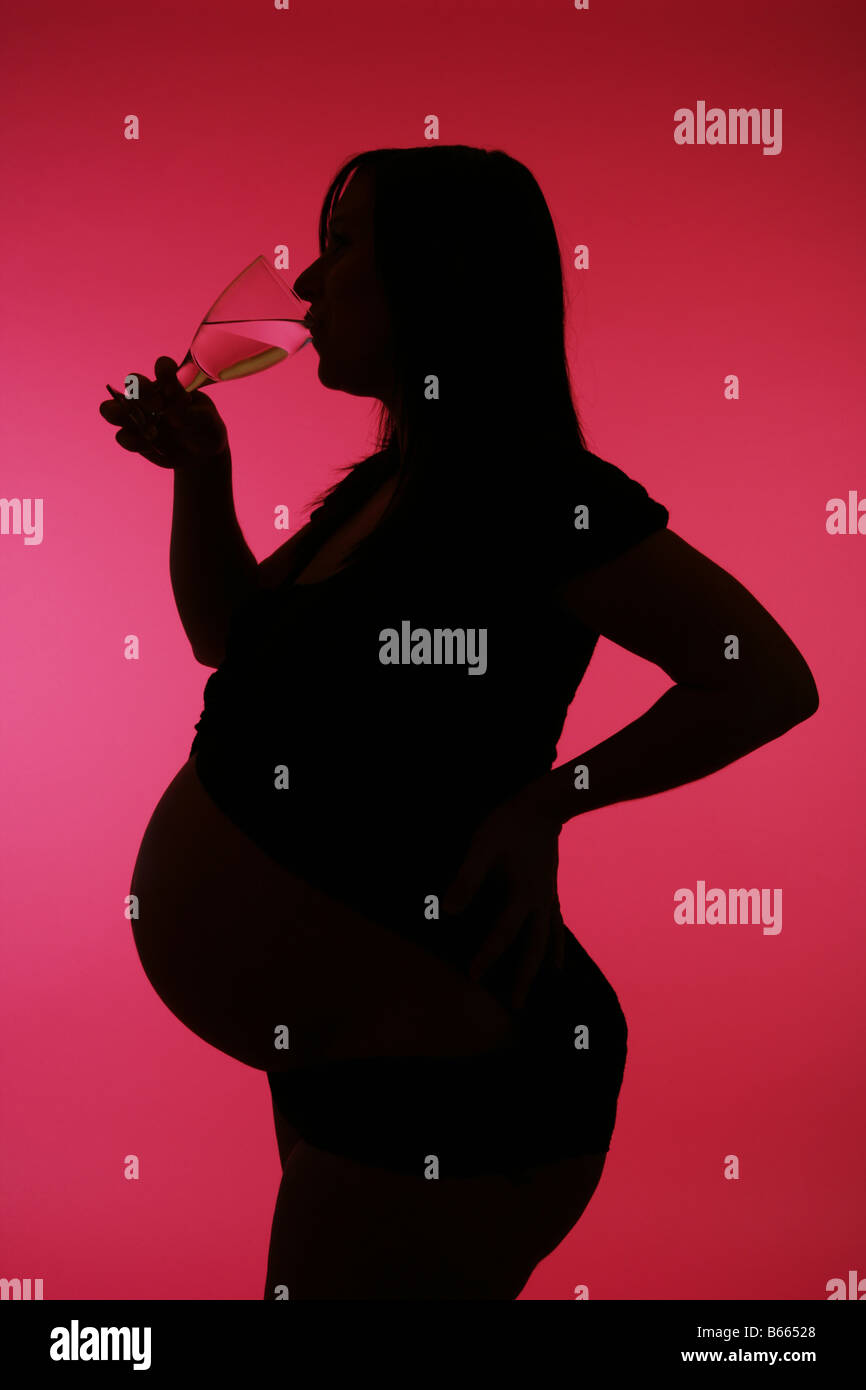 38 week pregnant woman silhouette against a pink background drinking