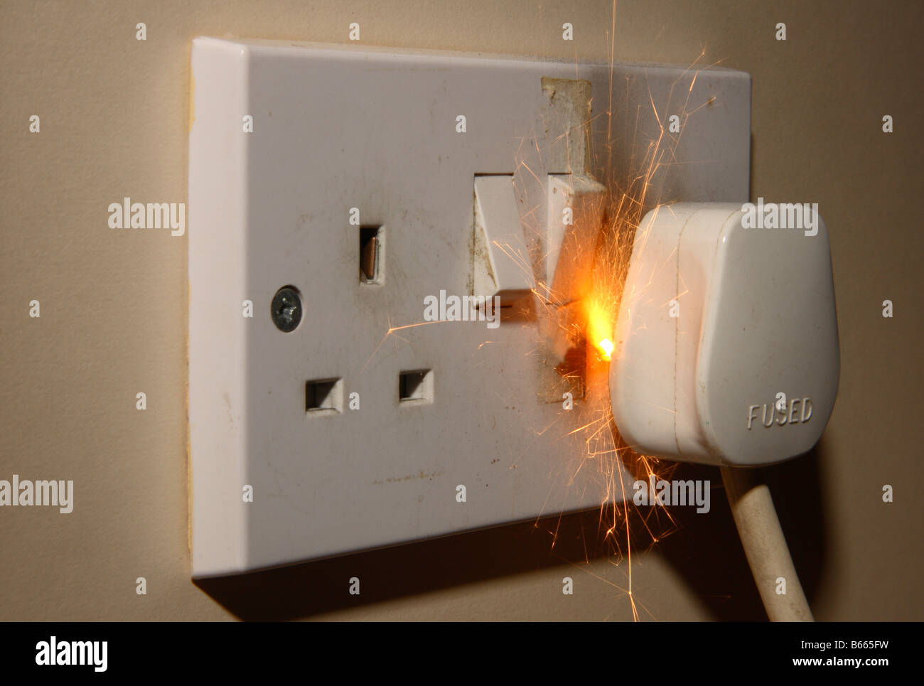 A fire in a 13A 240V electrical mains plug and socket. Stock Photo