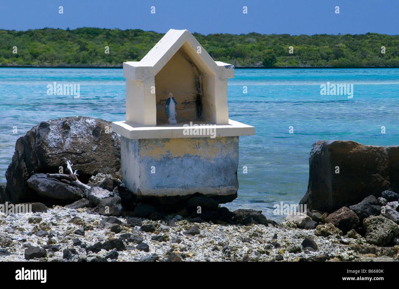 Shrine to the Blessed Virgin Mary on a small island with turquoise coral filled sea and Ile aux Aigrettes, Mauritius. Stock Photo