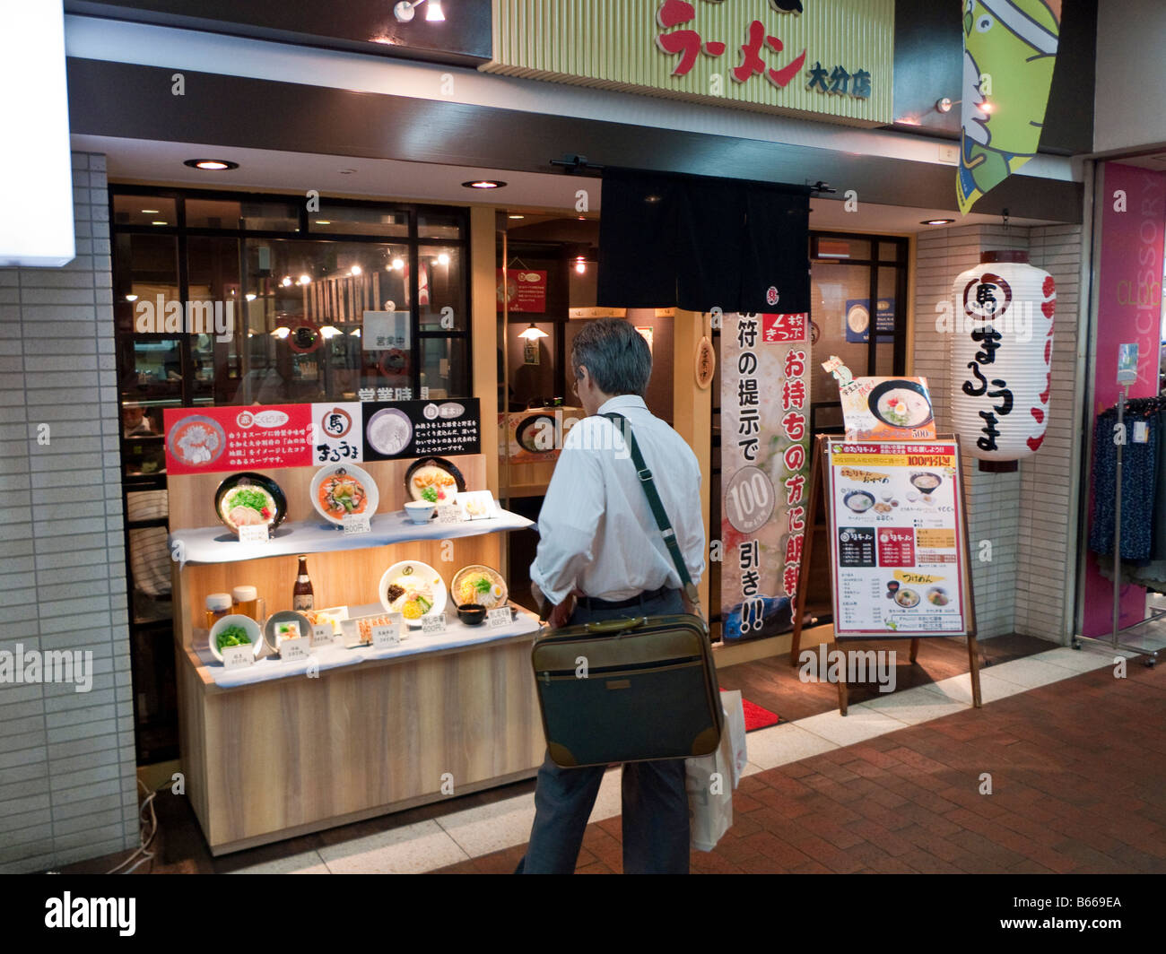 Man looking at plastic food display outside a Ramen noodle restaurant in Oita station Japan Stock Photo