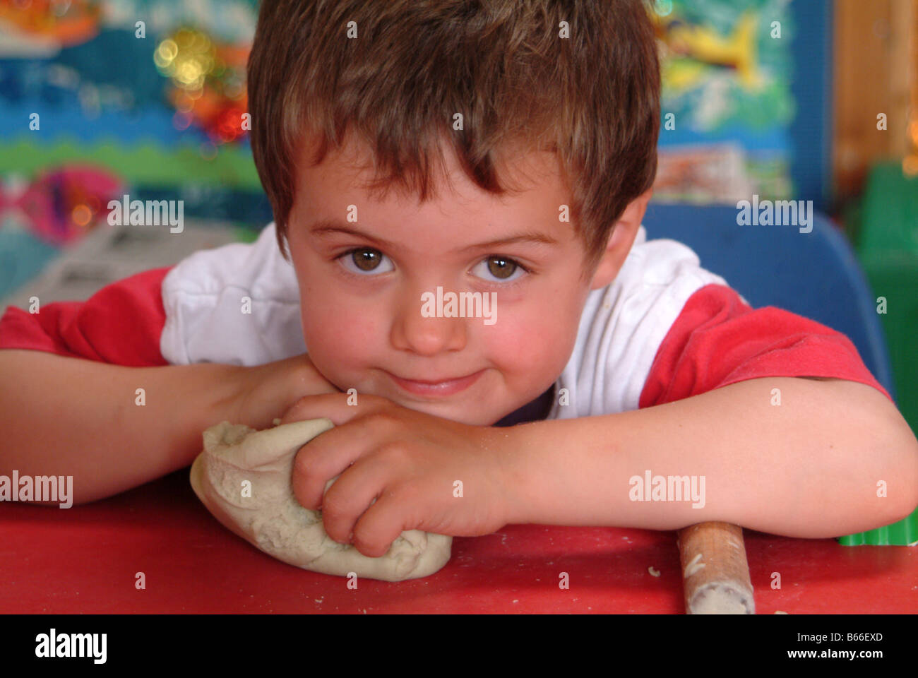 Portrait of a child with play dough and a rolling pin Stock Photo