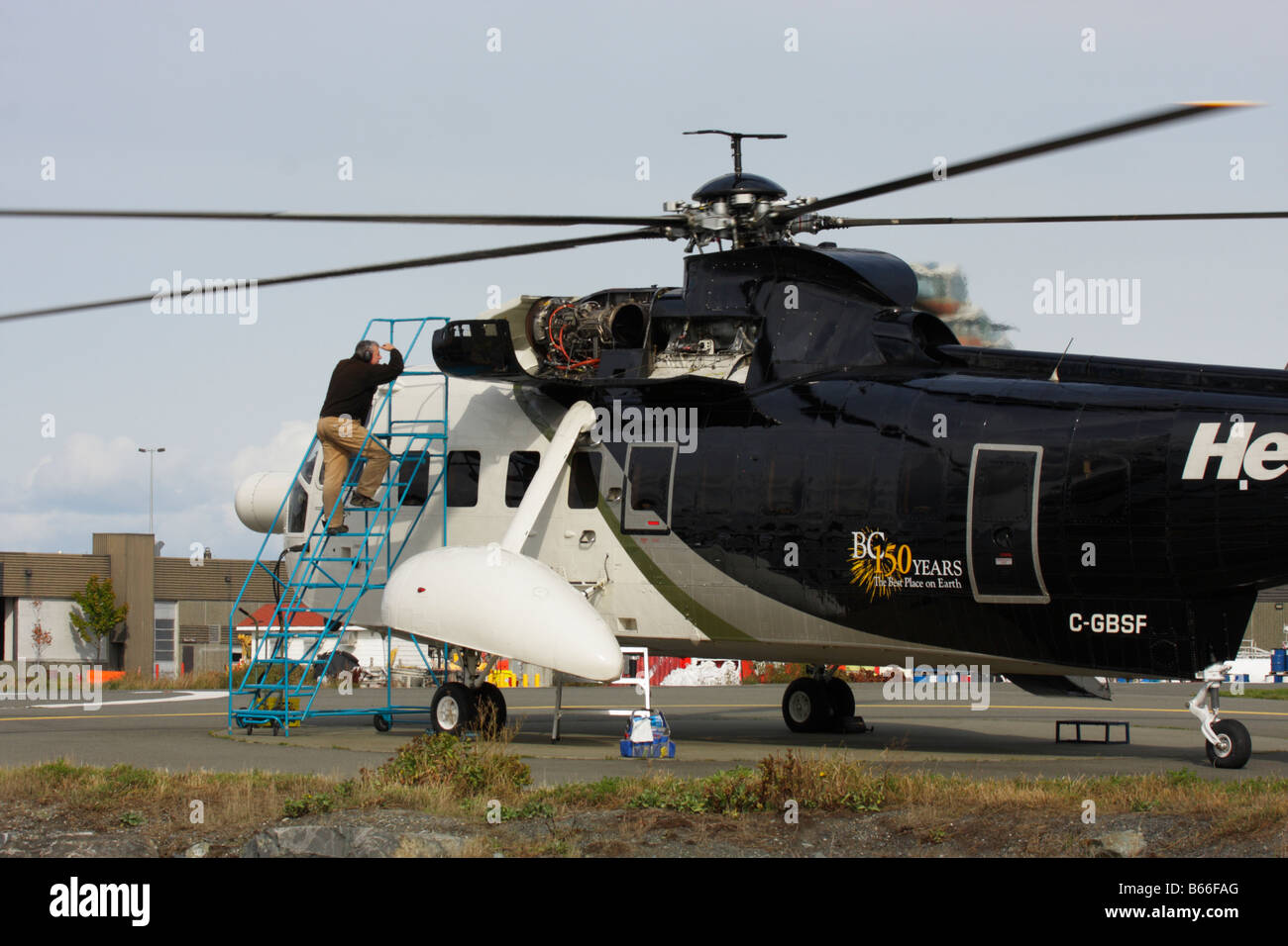 Aircraft mechanic working on Sikorski helicopter Victoria British Columbia Canada Stock Photo