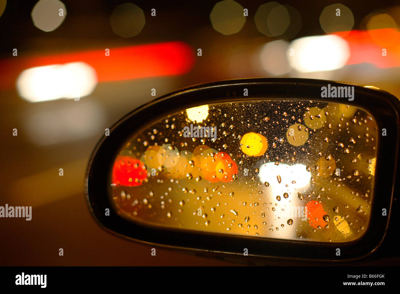 city car side rearview mirror with lights and raindrops Stock Photo