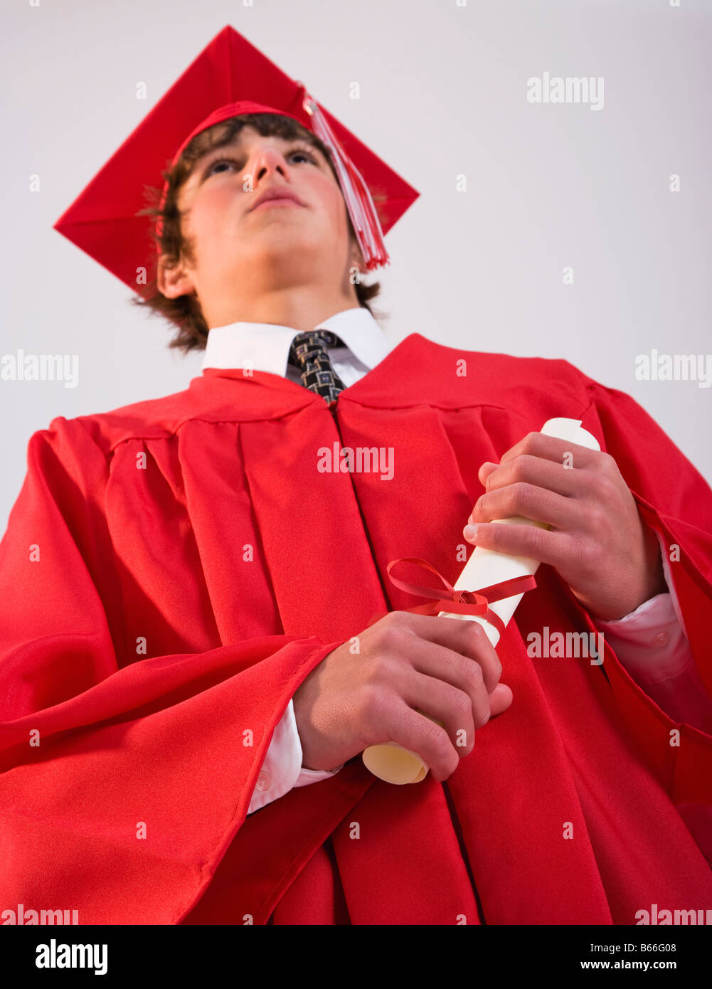 Male graduate in red gown with diploma Stock Photo