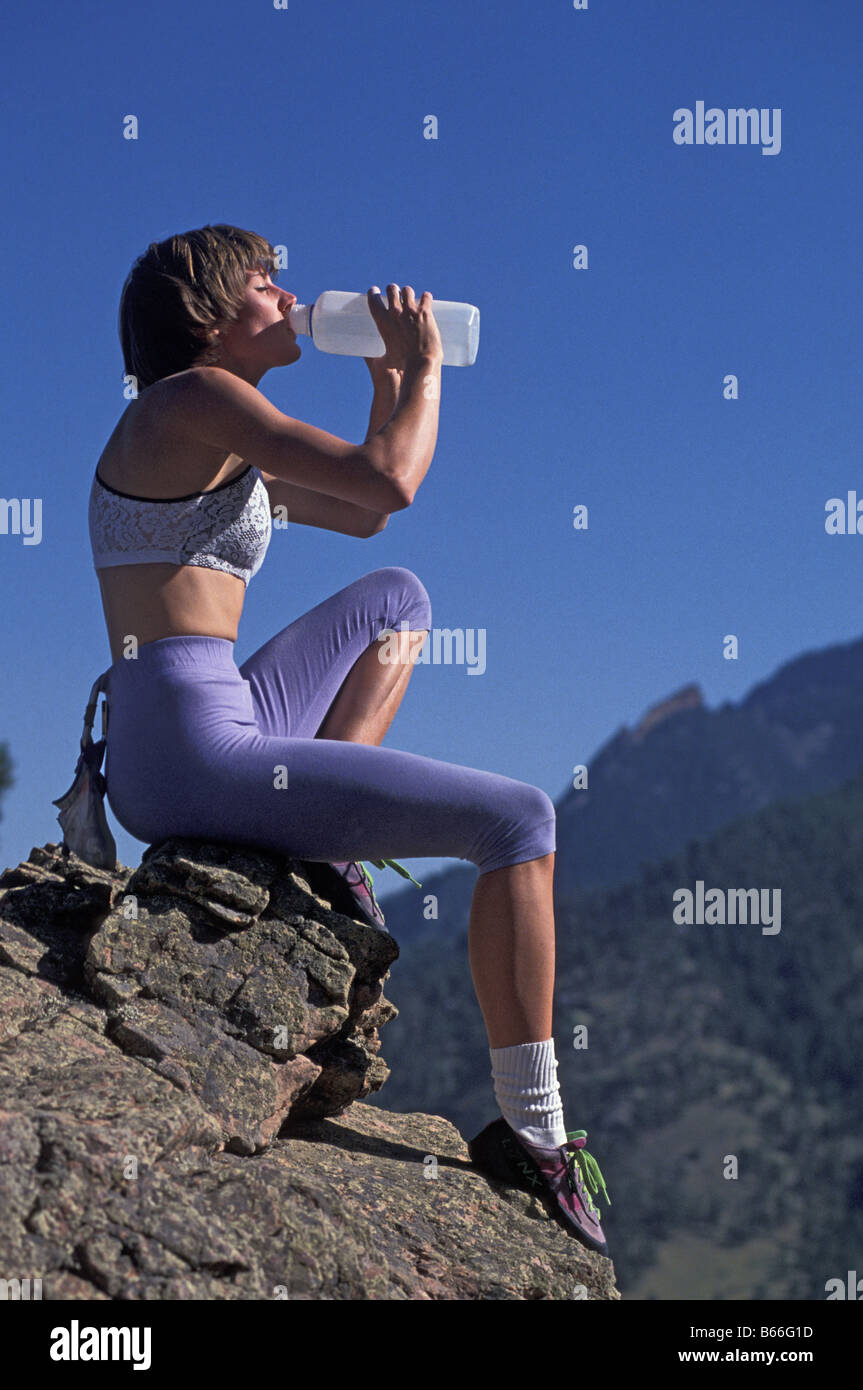Woman rock climber drinking during a rest break Stock Photo