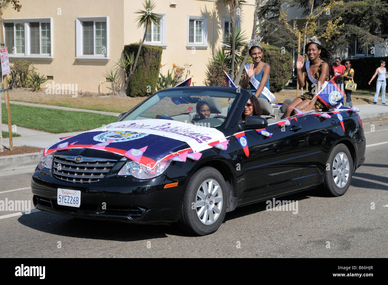 Two beauty queens representing Belize riding in a convertible American made car Stock Photo