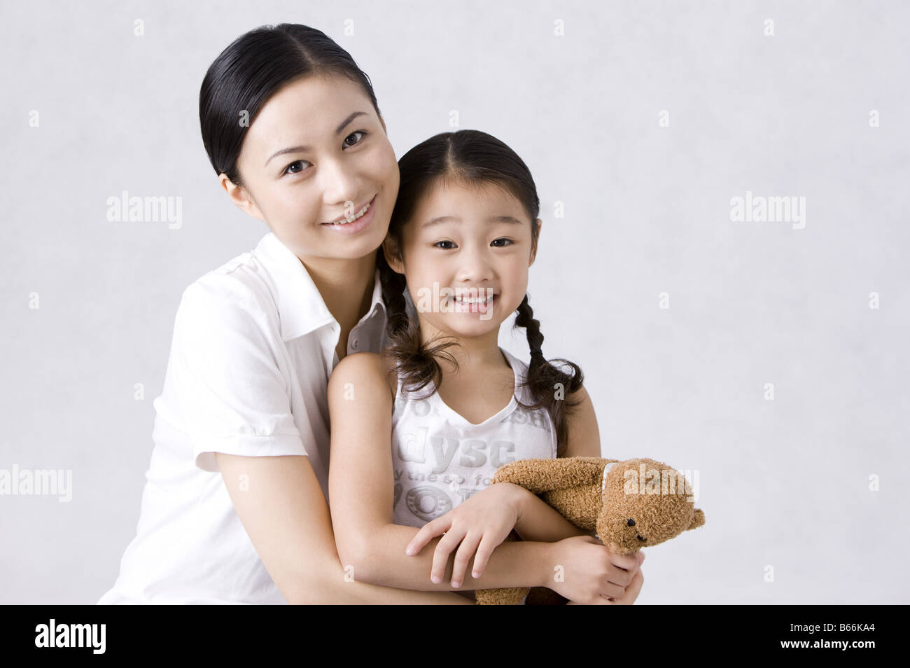 Young mother holding daughter and looking at the camera together Stock ...