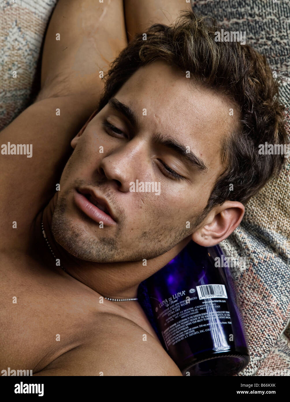 Young shirtless sexy man relaxes on the sofa appears drunk and intoxicated  Stock Photo - Alamy